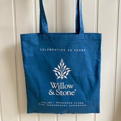 Blue tote bag with Willow & Stone branding on a white wooden background