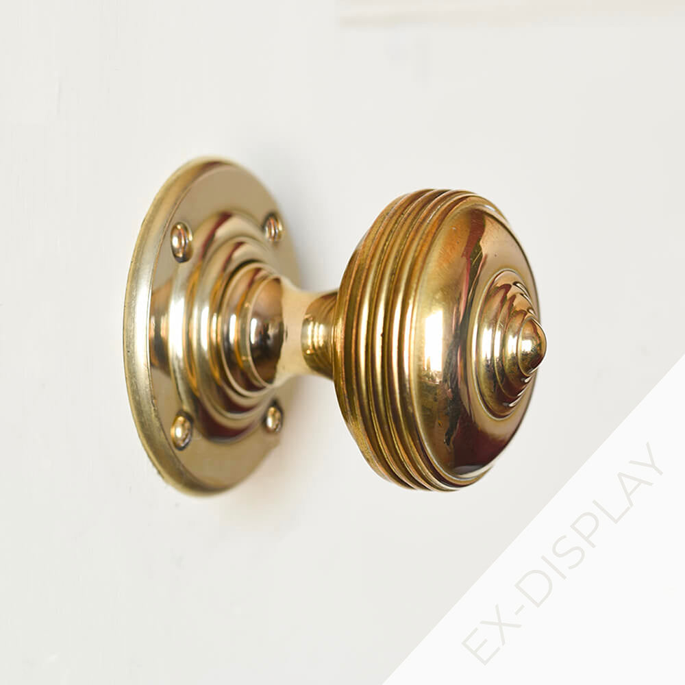 Brass Georgian style door knob on a light grey surface with a watermark and ex display text in the corner