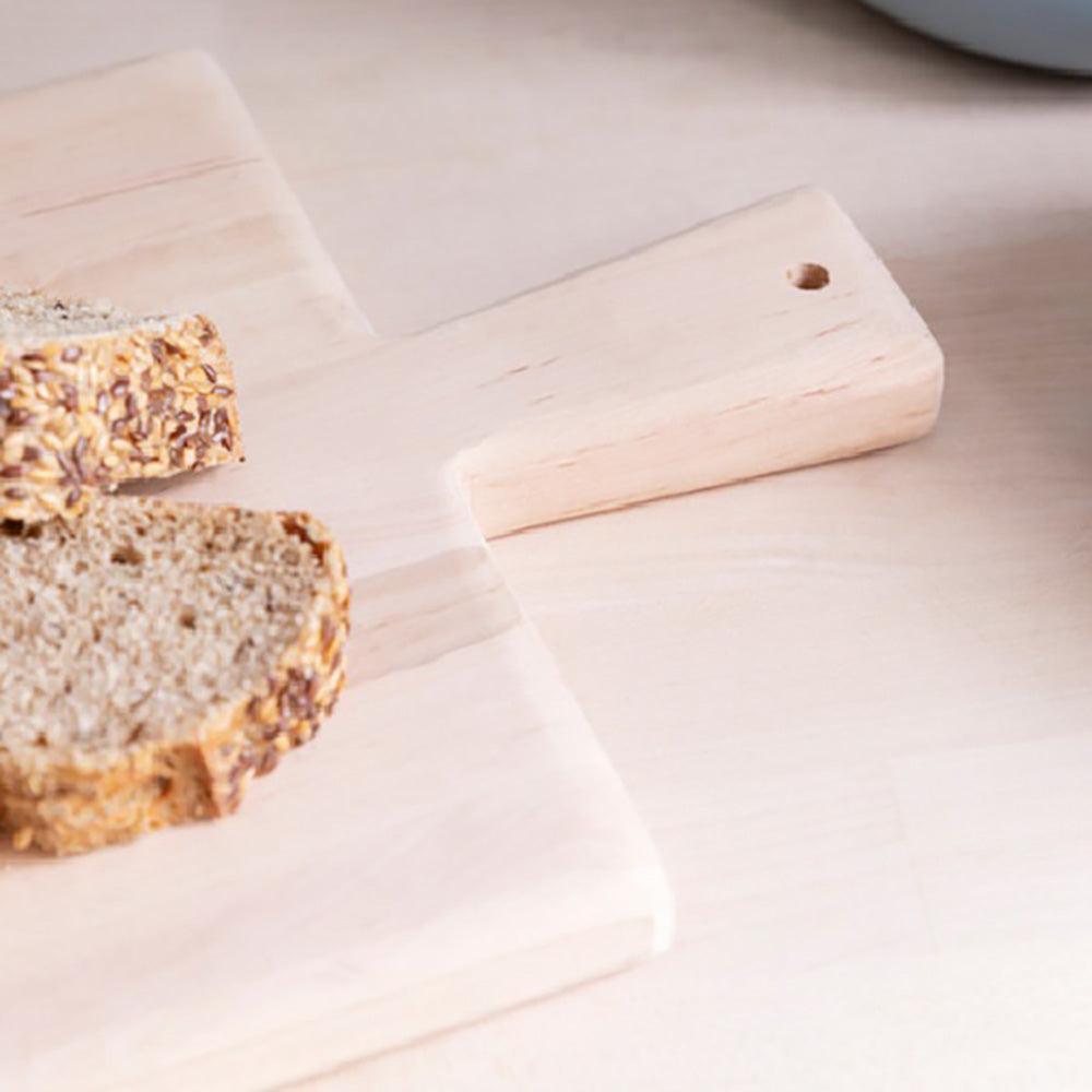 Close up of the handle of a short alderwood serving board with slices of wholegrain bread