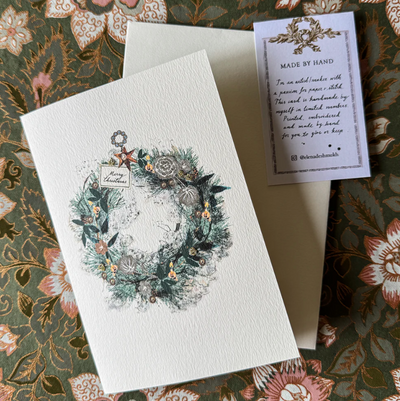 Greeting card with floral wreath design on a decorative surface