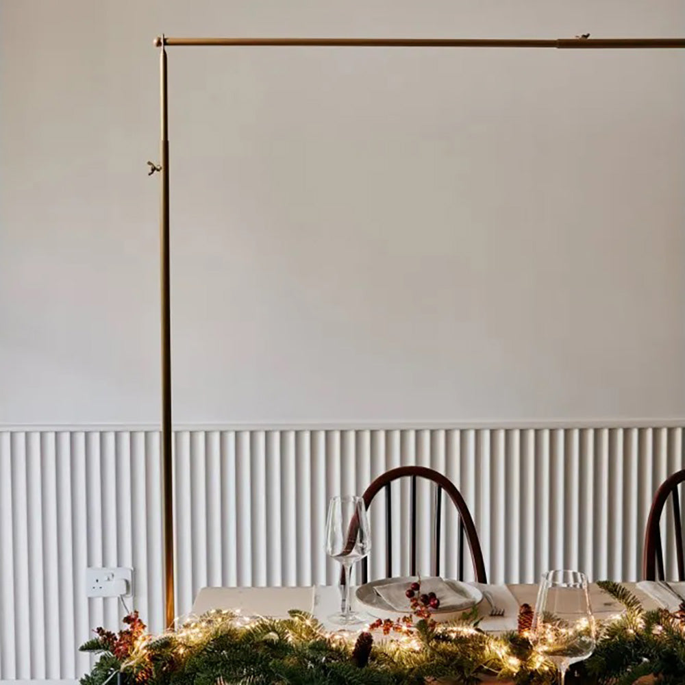 Over table display frame in gold with christmas foliage along the centre of the table with place setting and wine glass