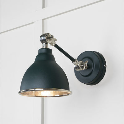 Hammered nickel Brindley wall light in dark blue against a white panelled wall