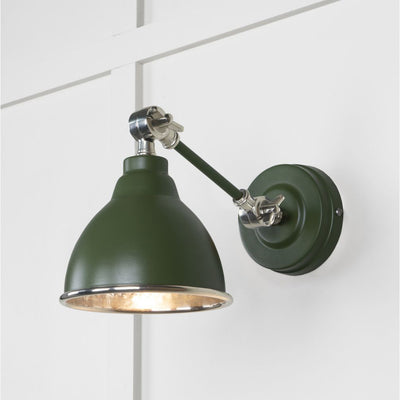 Hammered nickel Brindley wall light in dark green against a white panelled wall