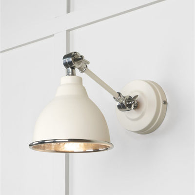 Hammered nickel Brindley wall light in white against a cream panelled wall