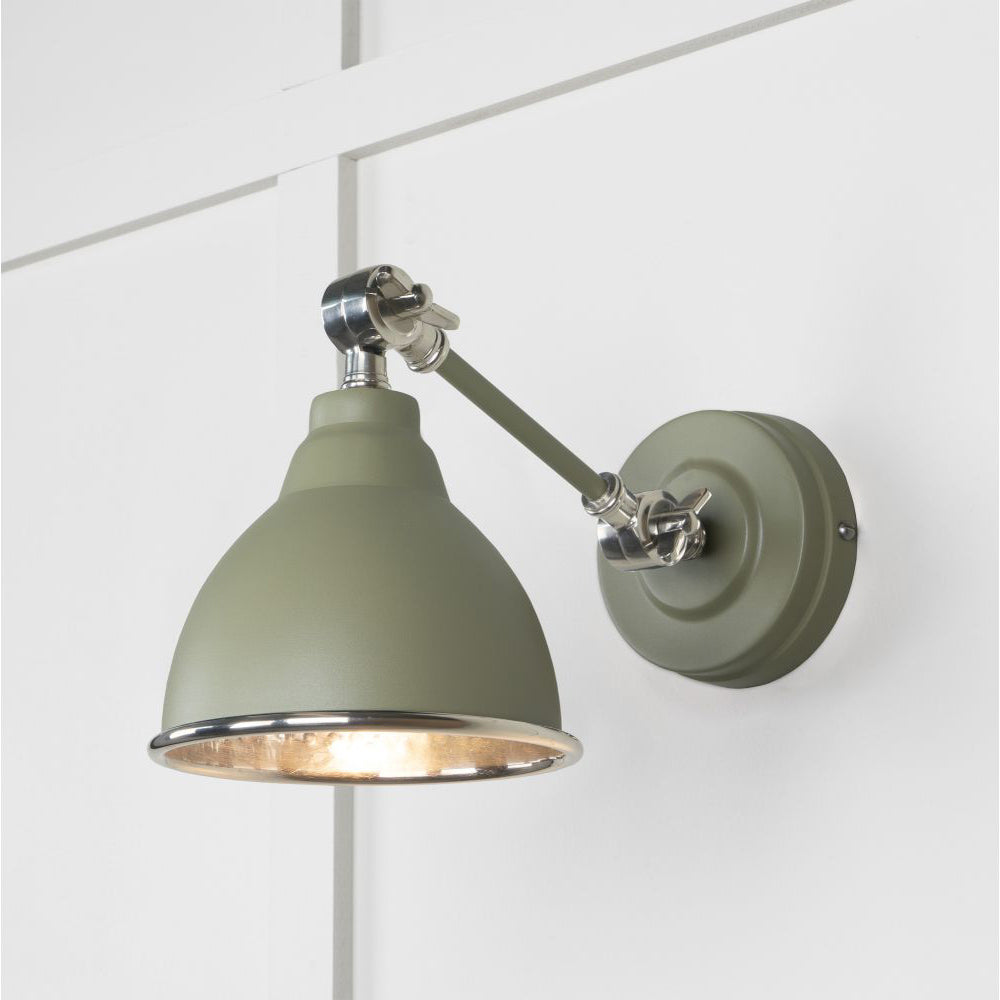 Hammered nickel Brindley wall light in white against a light green panelled wall