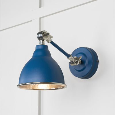 Hammered nickel Brindley wall light in blue against a white panelled wall