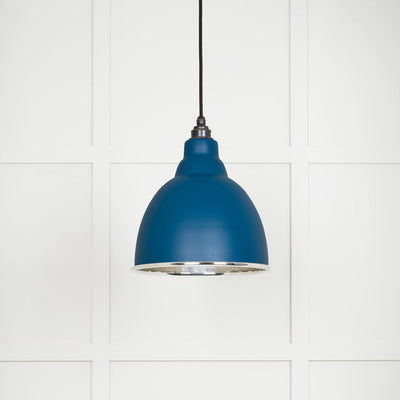 Hammered polished nickel Brindley pendant light in upstream hanging from a black fabric cable against a white panelled wall
