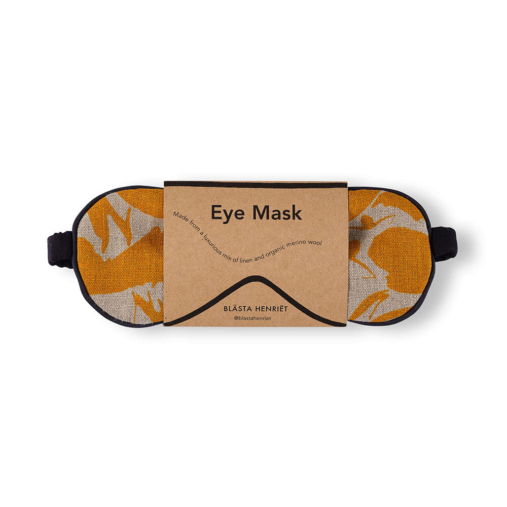 Mustard and white patterned eye mask that is made from linen and soft wool in packaging against white background 