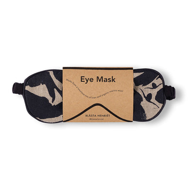 Navy and white patterned eye mask that is made from linen and soft wool in packaging against white background