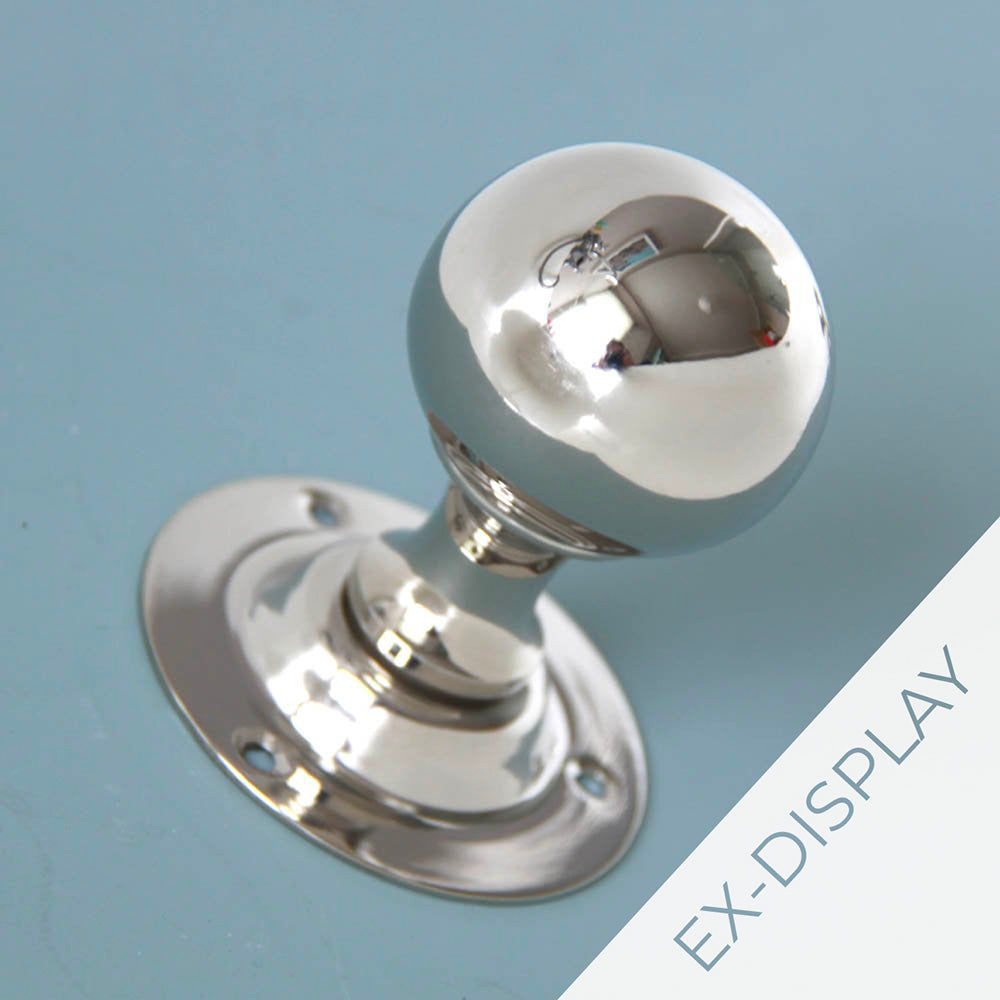 Polished nickel round door knobs on a pale blue background with an ex display watermark in the corner