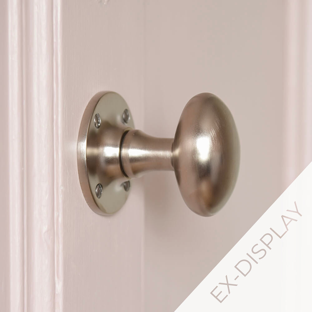 Satin nickel oval door knobs on a pale pink door with an ex-display watermark image in the corner
