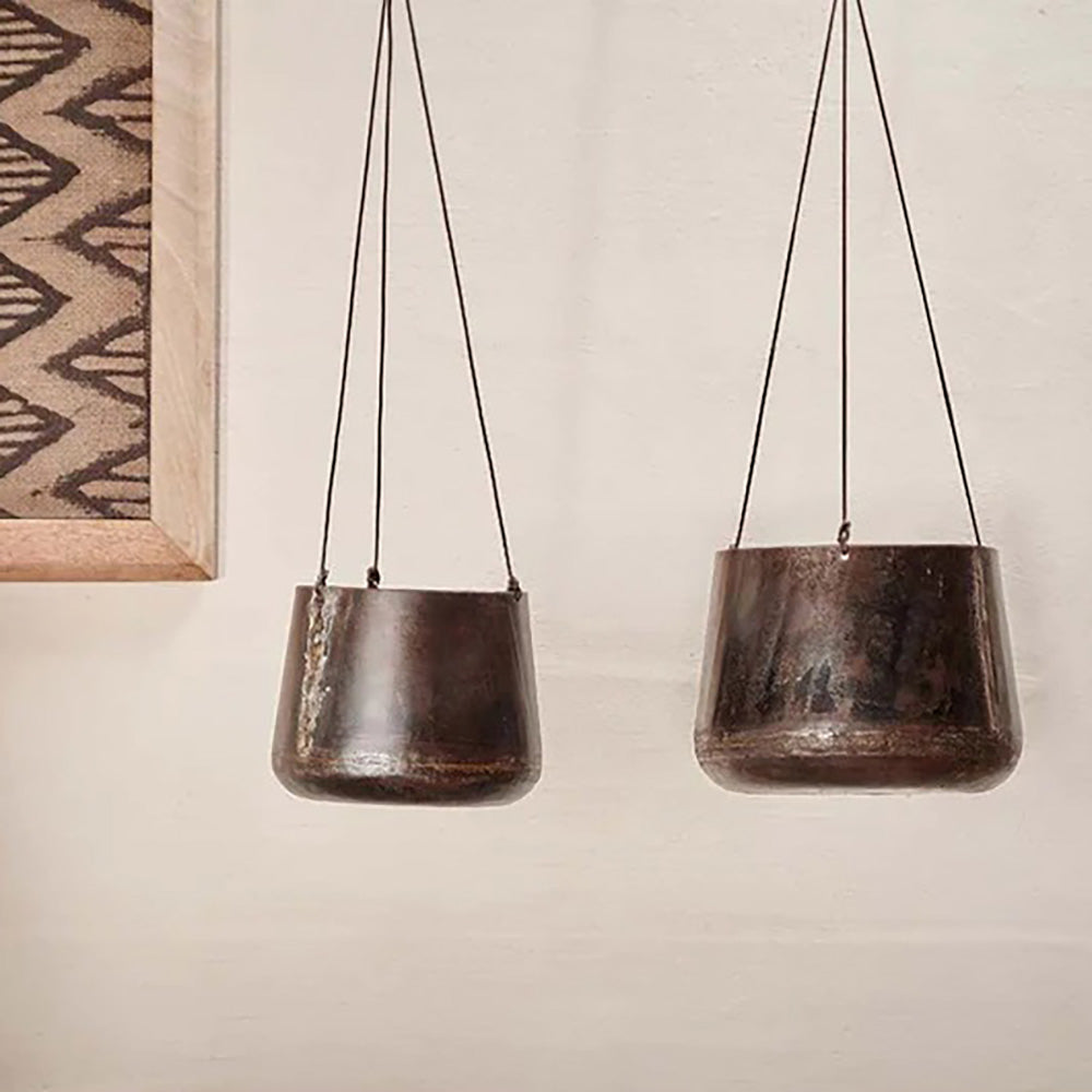 Small and large hanging planters made from reclaimed iron against pale background next to canvas framed print