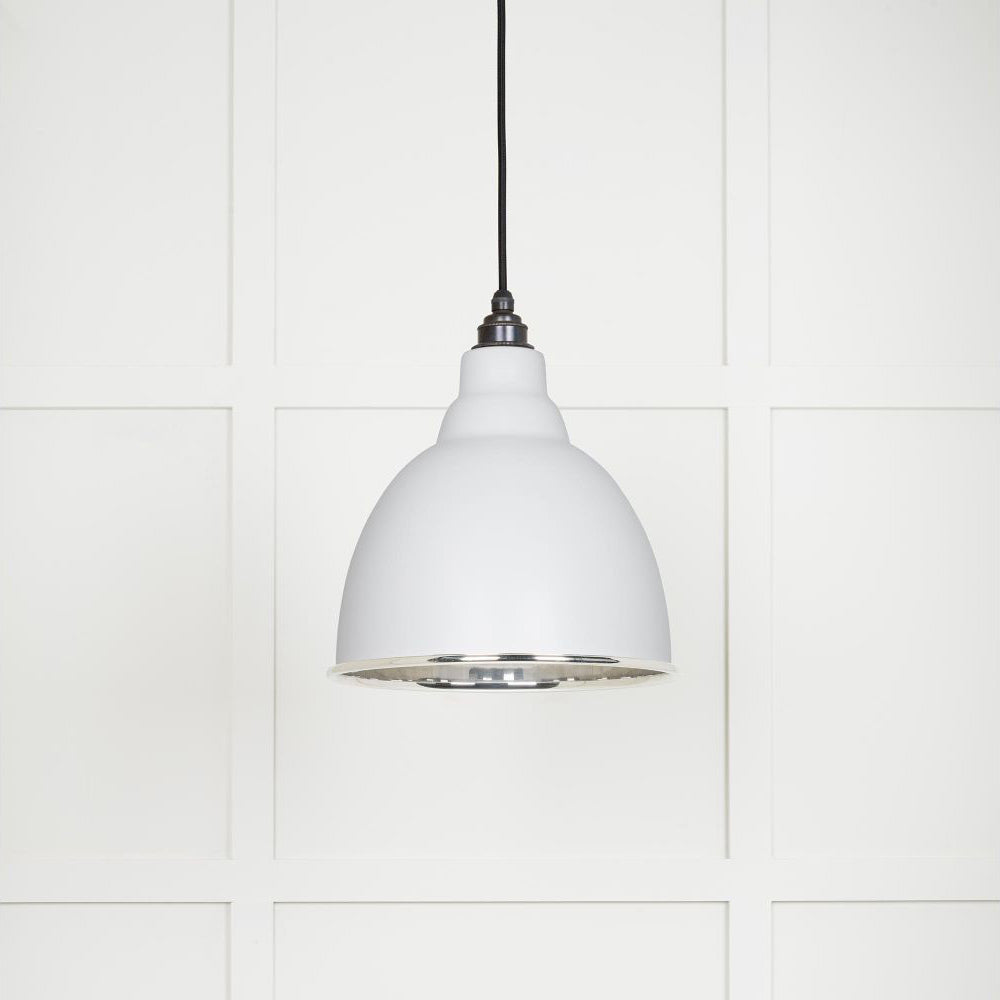 Smooth polished nickel Brindley pendant light with a powder coated finish in flock hanging from a black fabric cable against a white panelled wall