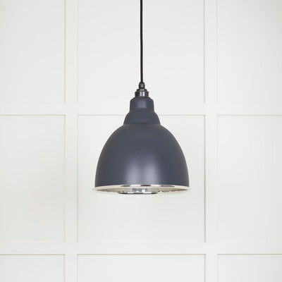 Smooth polished nickel Brindley pendant light with a powder coated finish in slate hanging from a black fabric cable against a white panelled wall