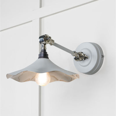 Smooth polished nickel flora wall light in birch against a white panelled wall