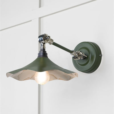 Smooth polished nickel flora wall light in heath against a white panelled wall