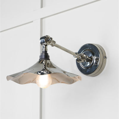 Smooth polished nickel flora wall light against a white panelled wall