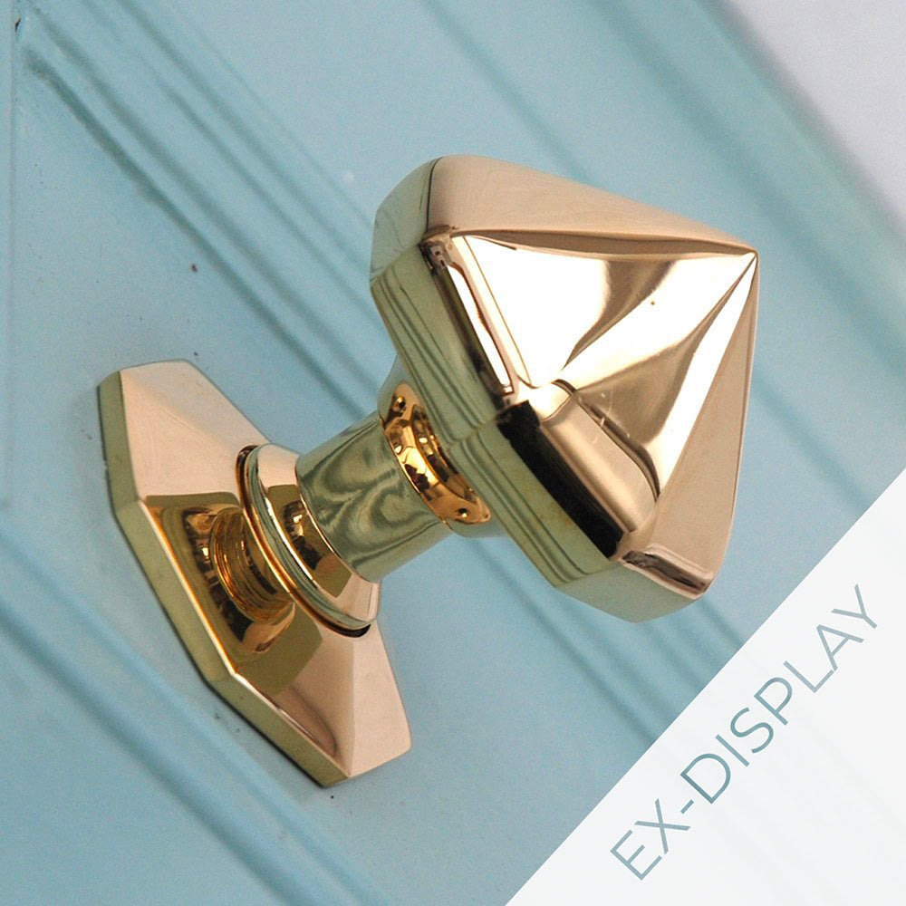Solid brass pointed octagonal door pull on a light blue panelled door with an ex-display watermark in the corner