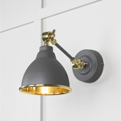 Solid brass wall light powder coated in dark grey against a white panelled wall