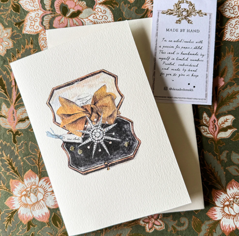 Card with decorative design on a floral-patterned surface