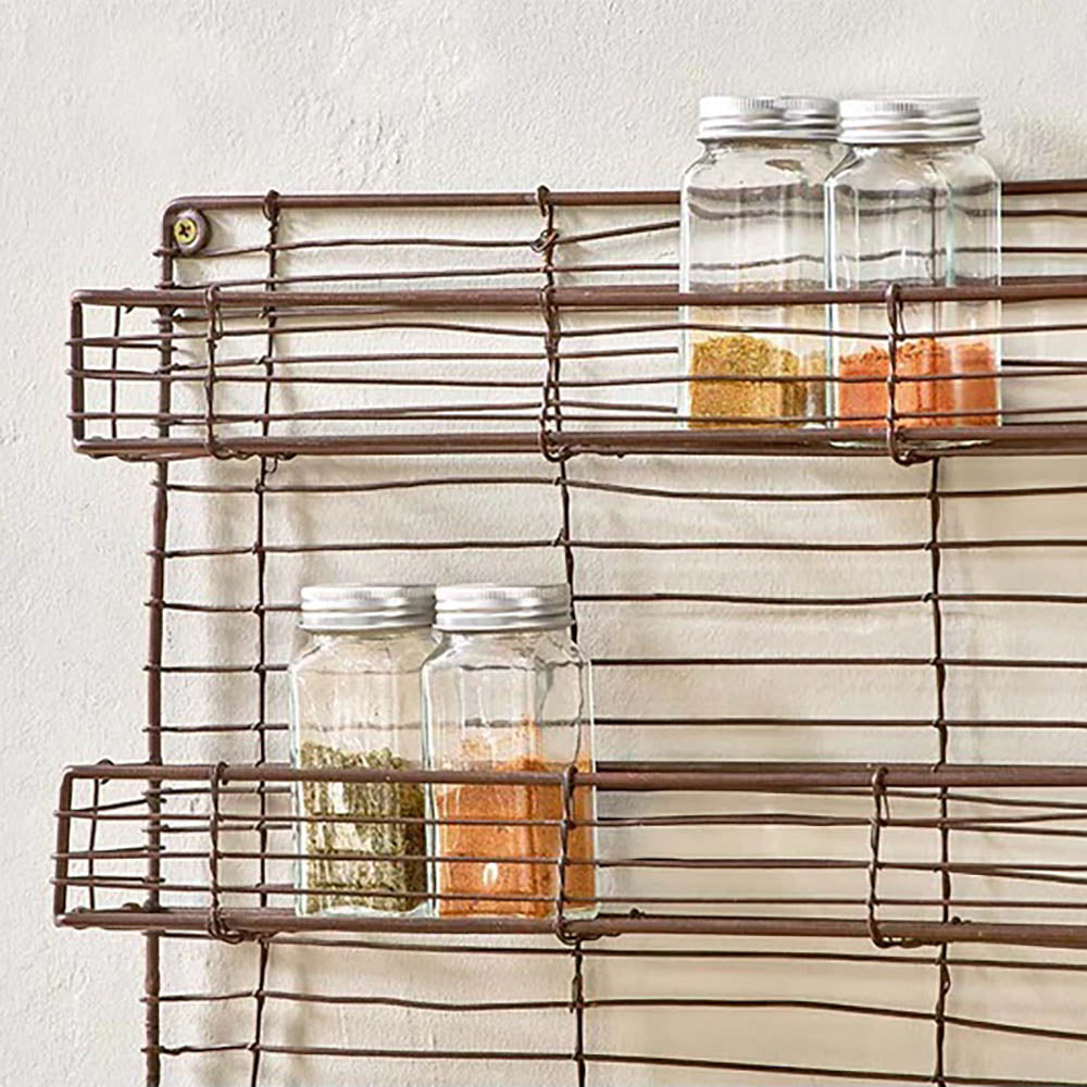 Wire spice rack with glass spice jars against a pale background