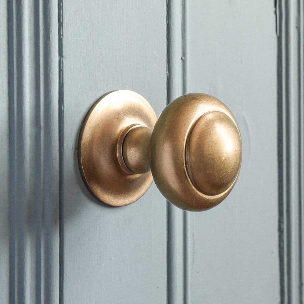 Round central front door pull in aged brass