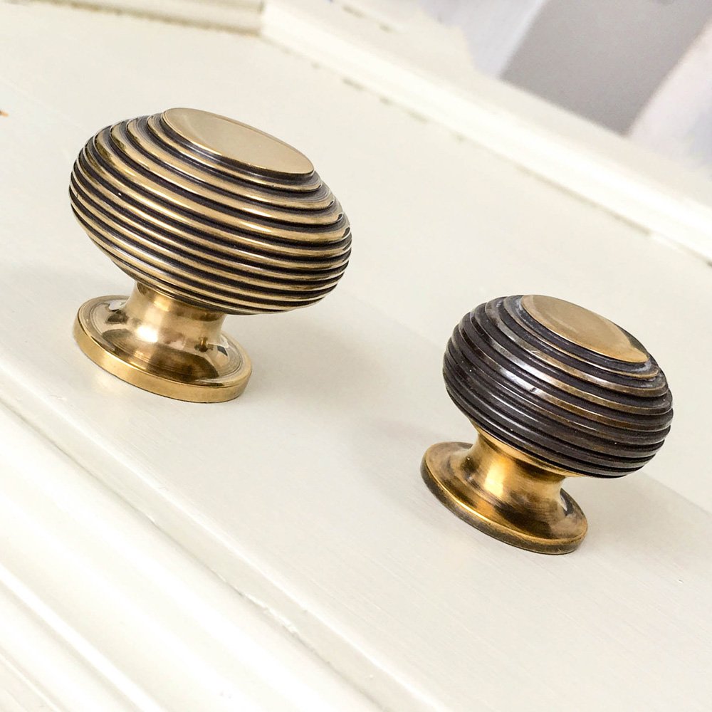 Aged brass cabinet knobs on white background