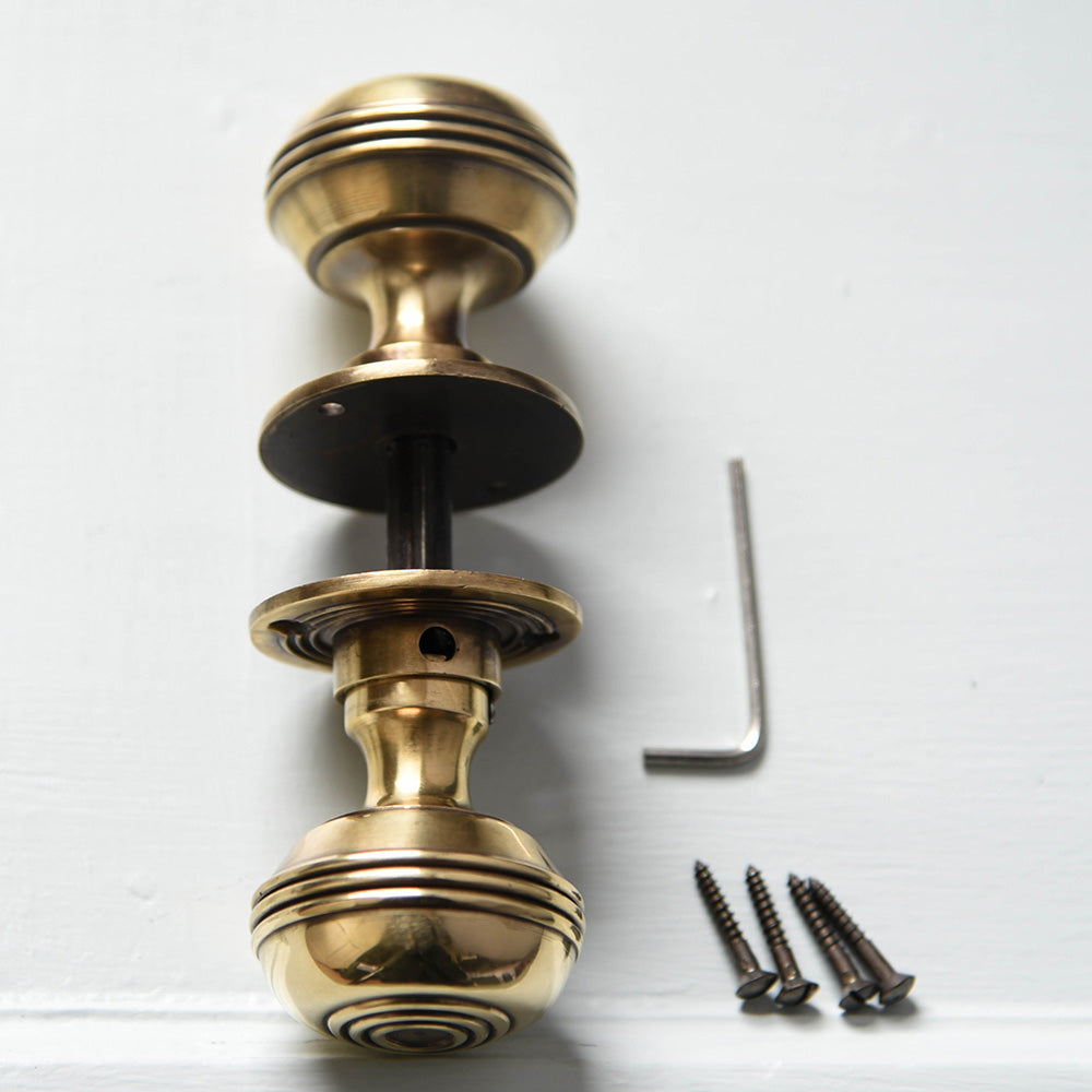 Pair of polished antique brass regency bloxwich door knobs with fittingss