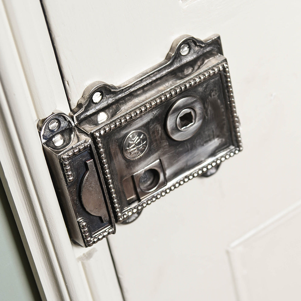 Aged nickel regency rim latch on white door