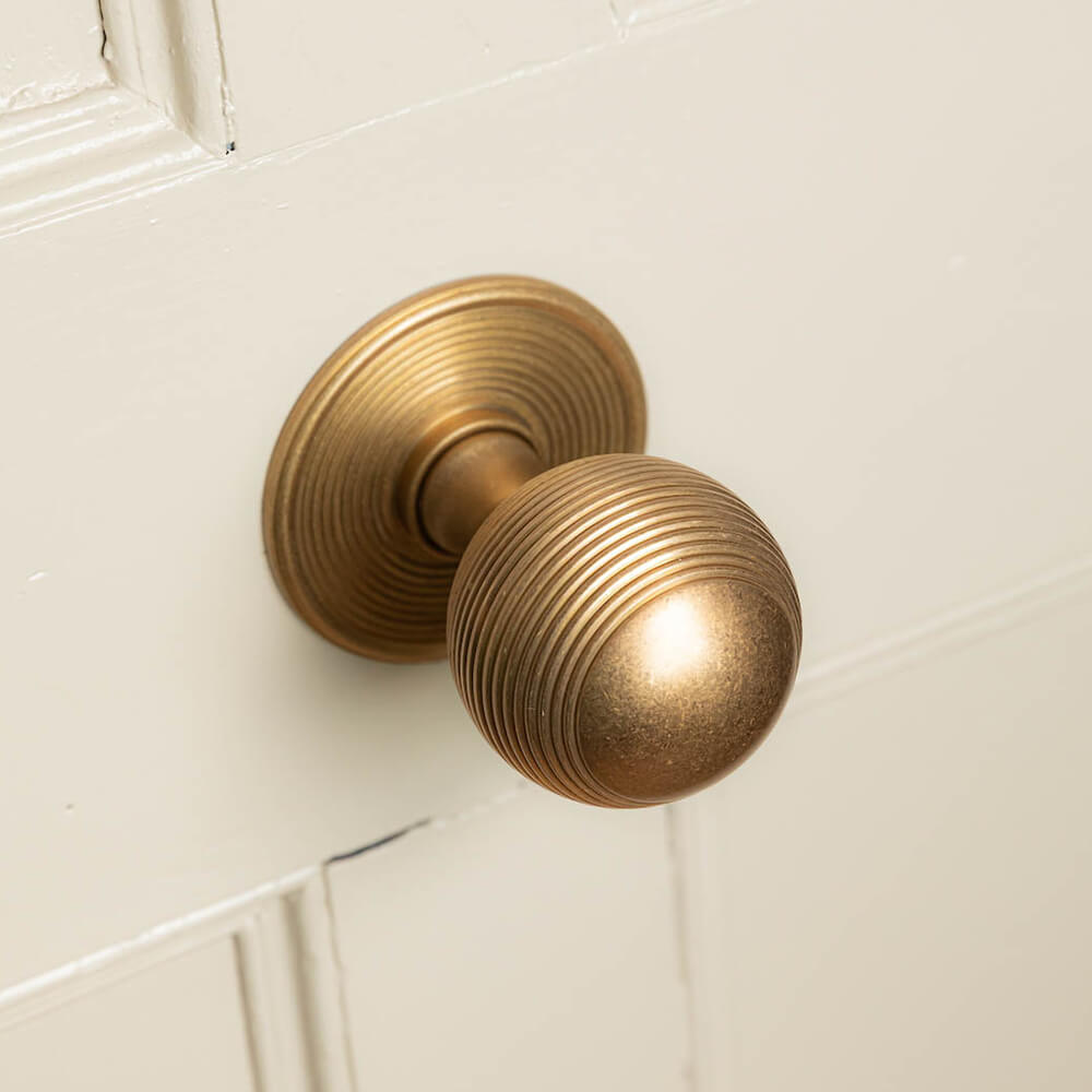 Aged brass large beehive door pull centre knob on a front door
