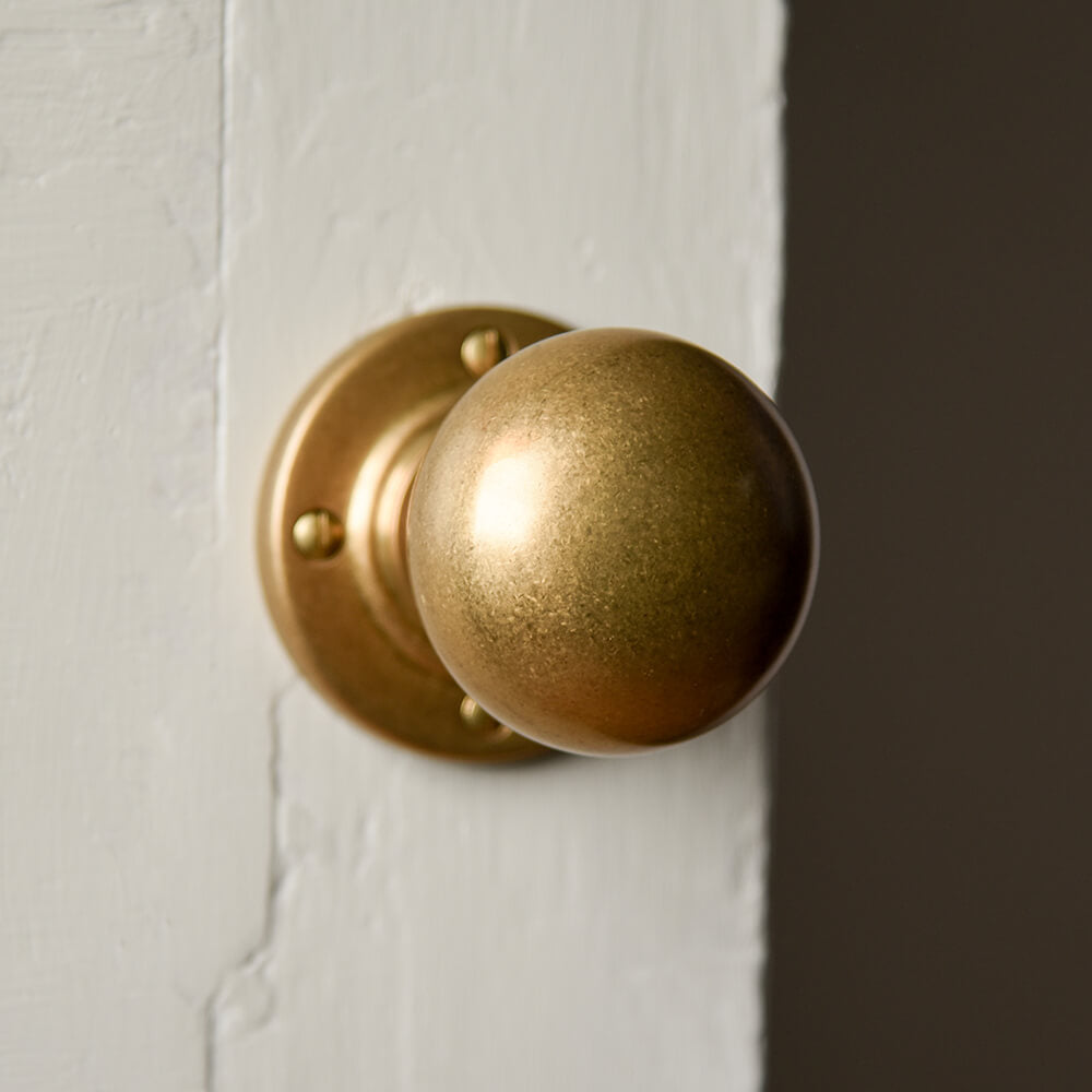 Bun door knobs seen from the front in aged brass