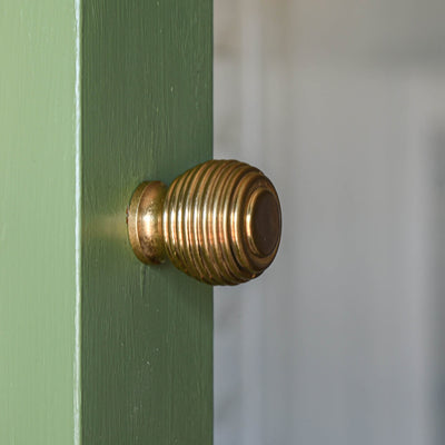 Aged Brass Queen Anne Beehive Cabinet Knob on open green door