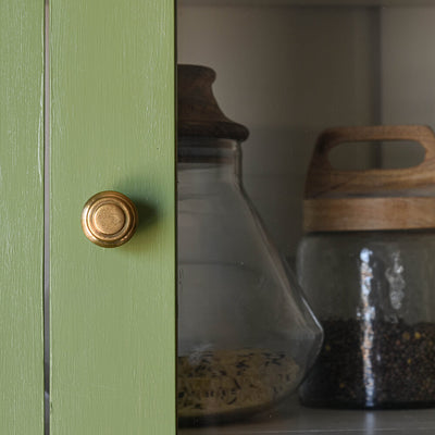 Aged Brass Queen Anne Beehive Cabinet Knob seen on glazed green pantry cupboard