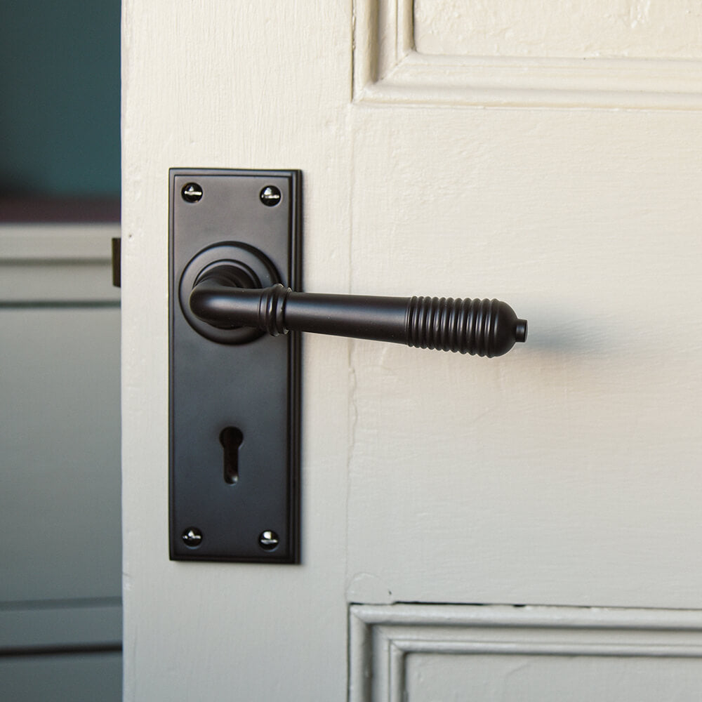 Aged Bronze Reeded Lever Lock Handle with Keyhole on door