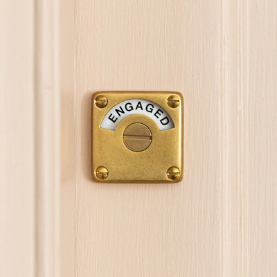 Aged brass vacant engaged latch lock on pink door