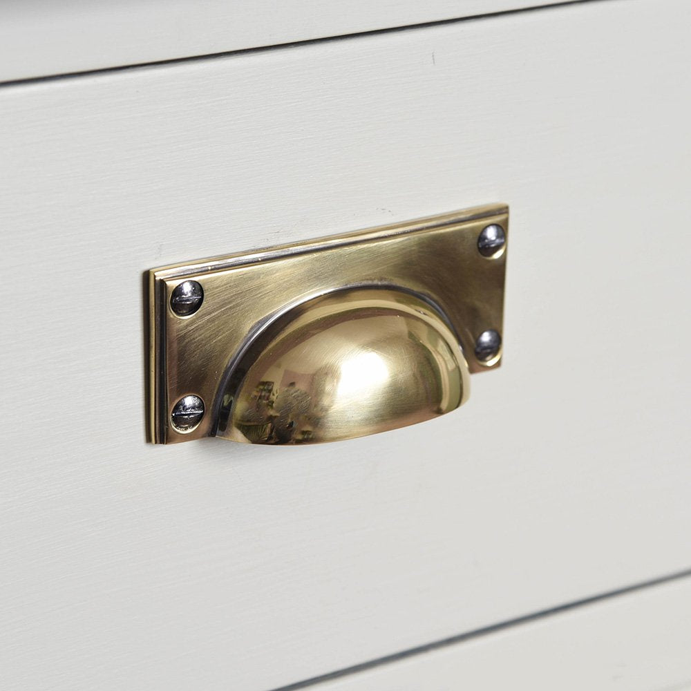 An art-deco style drawer pull in an aged brass finish