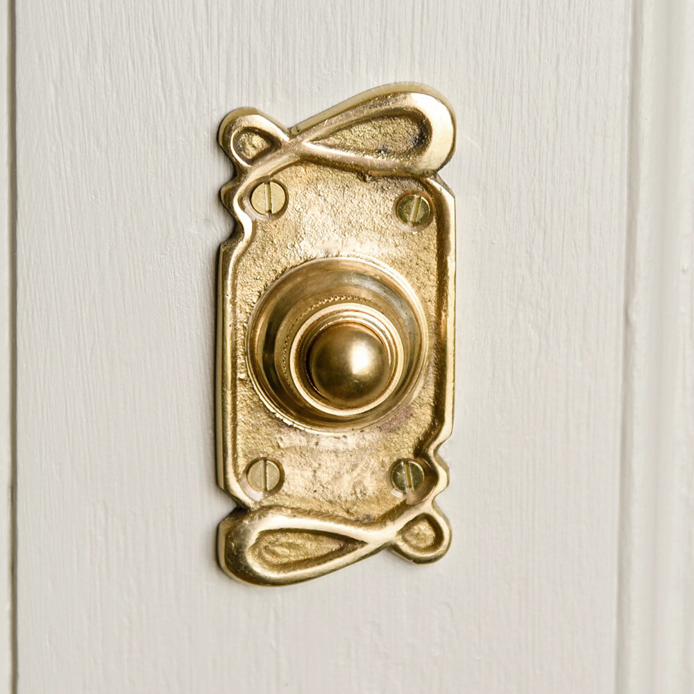 Art Nouveau brass bell push on door frame