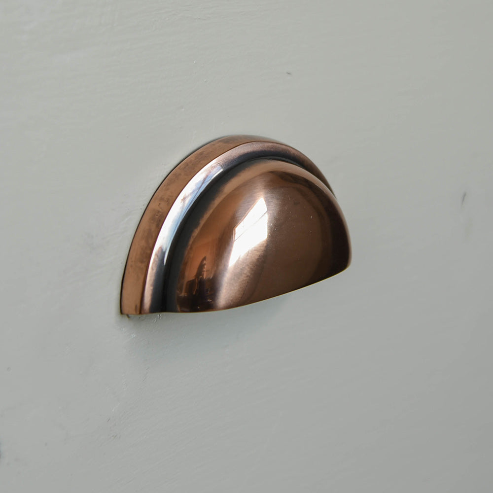 The regency concealed drawer pull in a polished bronze finish