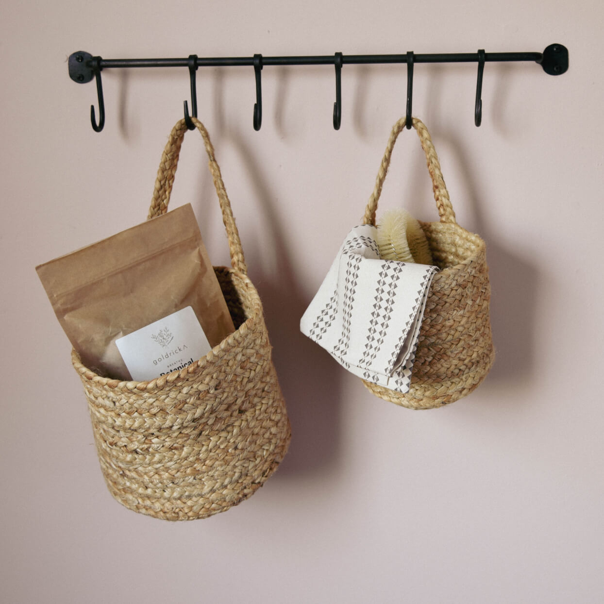 Pair of single handled Baskets on hook rail holding household items