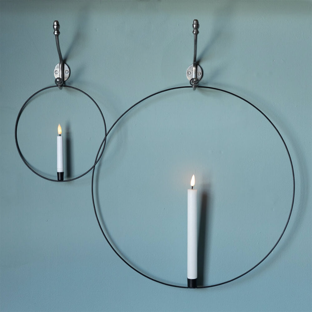 Black hoop with LED candle in two sizes seen hung from hooks