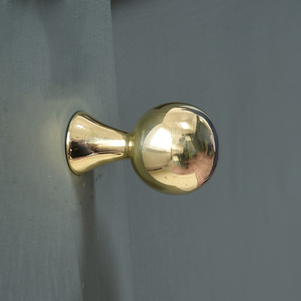 Brass ball shaped cabinet knob on fluted neck