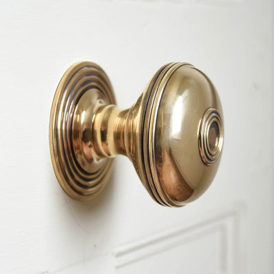 A Prestbury Door Pull in Aged Brass fitted to a door