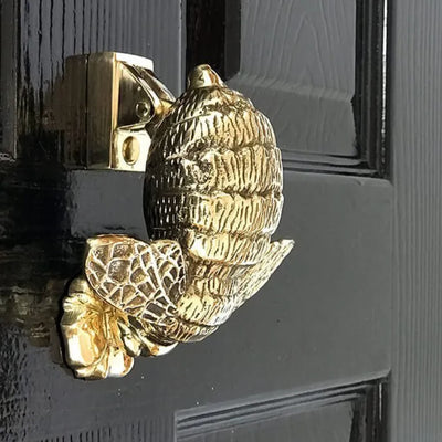 brass beehive door knocker on black door