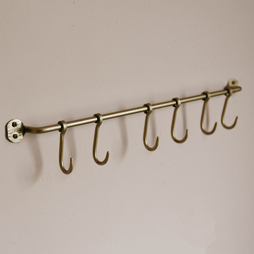 Brass Rail with 6 fixed rustic hooks mounted on a kitchen wall