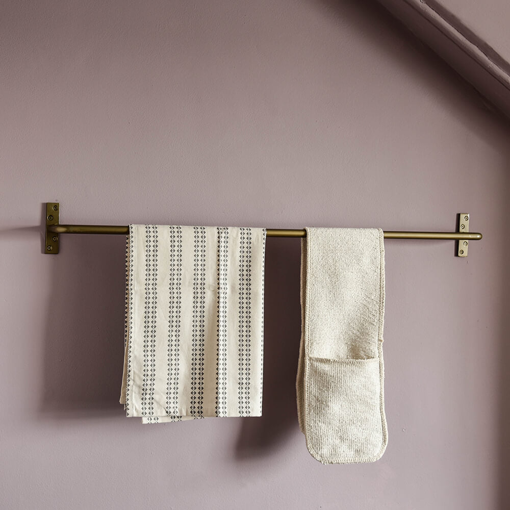 brass rail with oven gloves and tea towel