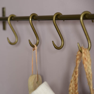 Row of S Hooks on hanging rail in brass