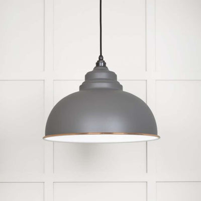 A warm grey pendant light shade with copper trim
