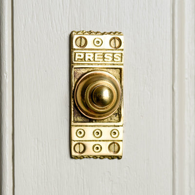 Classic bell push with ornate design seen on door frame