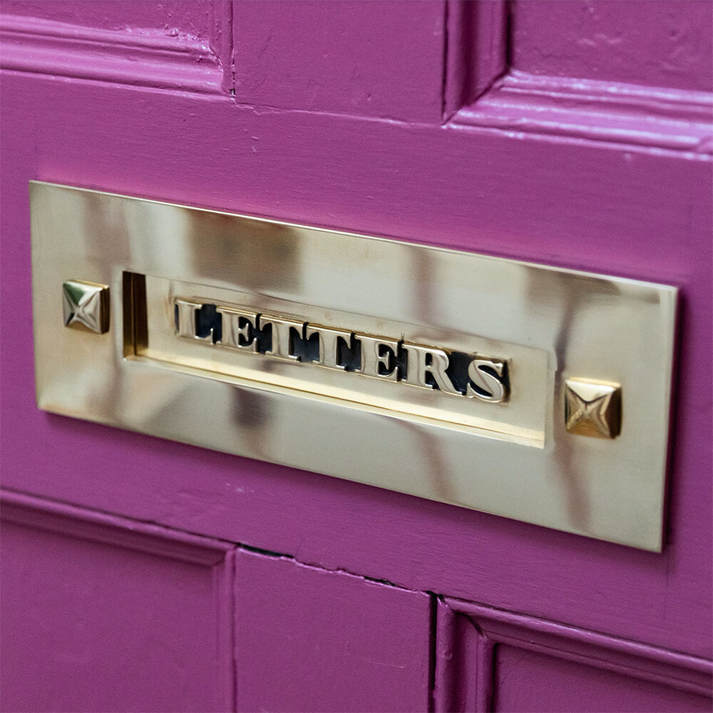 Classic Letters Letterplate in Brass seen mounted on bright pink front door