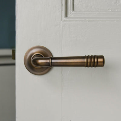 Distressed Antique  Brass Crest Lever Handles on Covered Rose